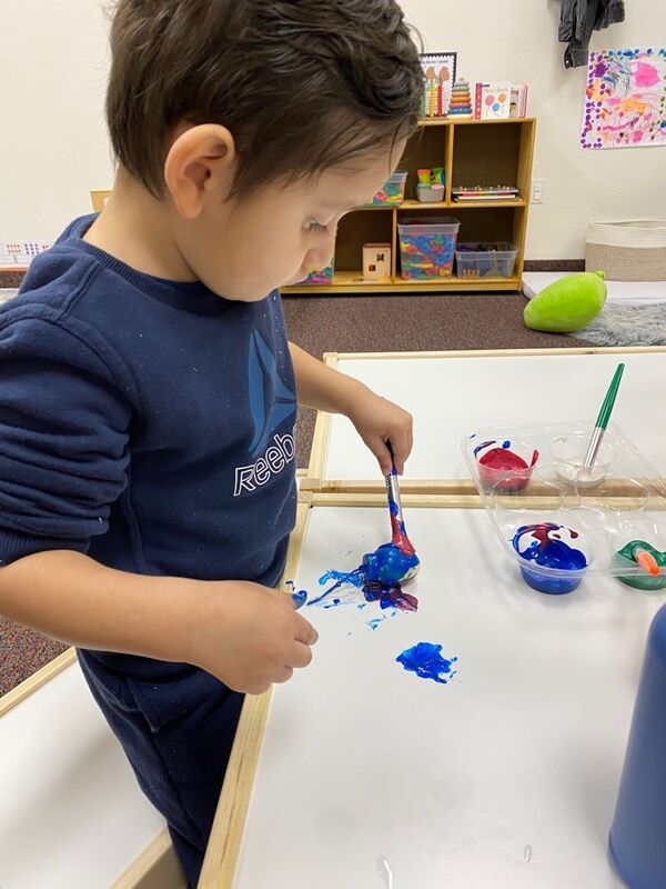 A child painting at an art table