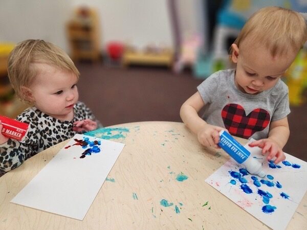 Toddlers painting with dot markers