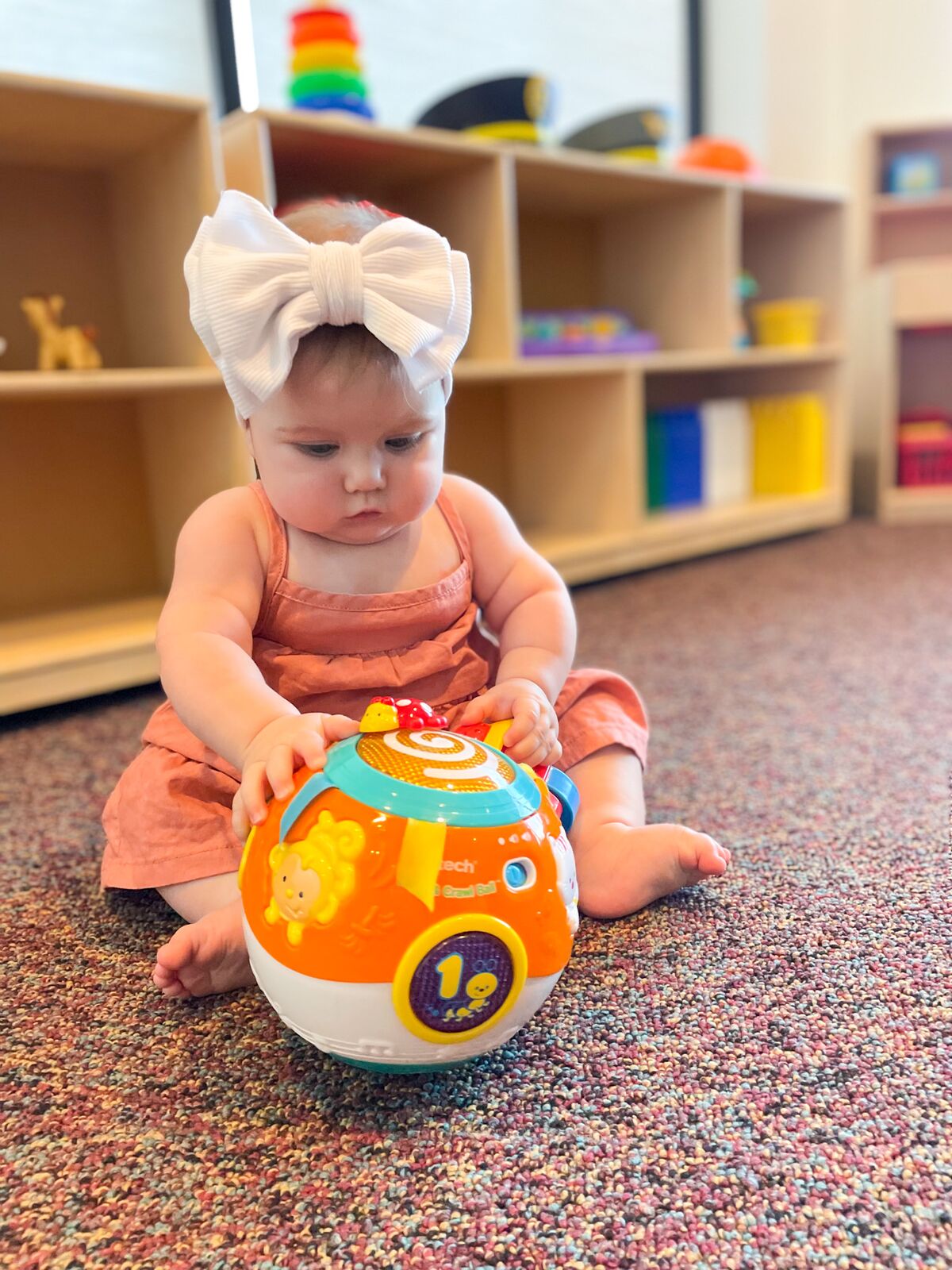 An infant playing with a light-up toy ball