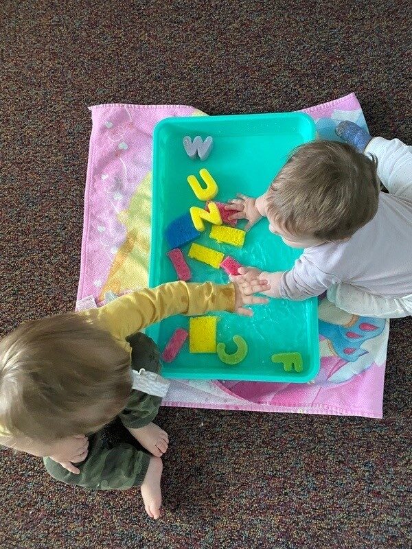 Children finding letters on a sensory play mat