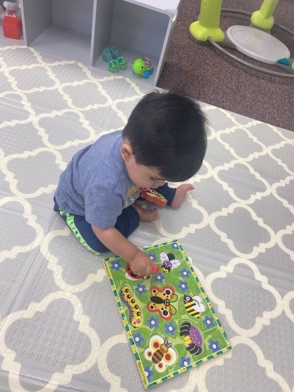 A child exploring a textured activity mat