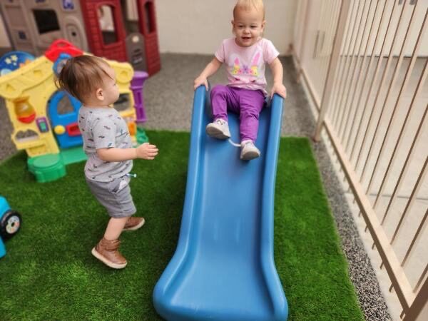 Toddlers climbing and sliding in the indoor play area